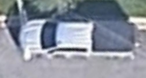 Low-resolution, blurred partial photograph of a pickup truck rear bumper corner